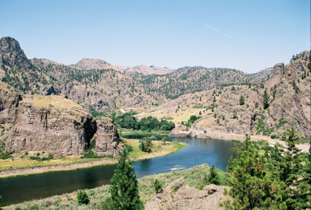 [Missouri River winding through the mountains from the back right to the left. There is some river level ground around the river, so it's not as if the river carved a canyon out of the rocks.]